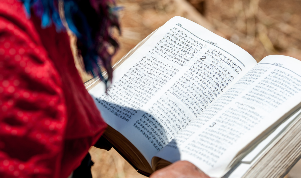 Picture: An old Christian woman holds up a bible printed in Miao script in Xiaoshuijing village, Fumin county.