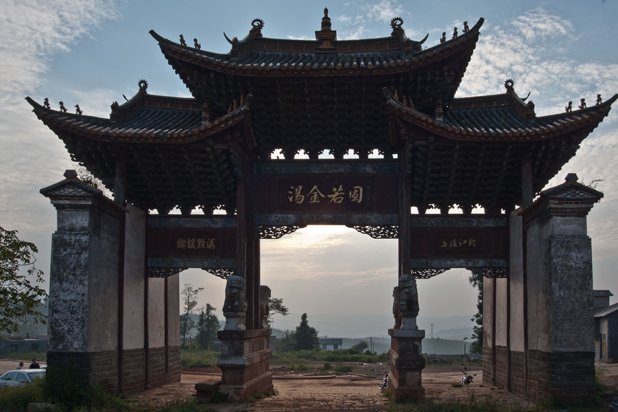 Picture: Shengjingguan 胜境关 is the old border crossing from Yunnan to Guizhou near Fuyuan. The archway with the four stone lions described by many early explorers still stands, as does the (now renovated) stone gate. From here a narrow path leads down into a peaceful valley, presenting the modern-day traveller with views that have changed little since the caravan days.